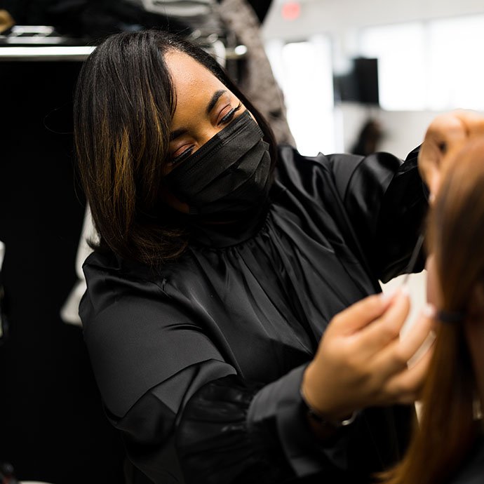 Woman with mask doing makeup on other woman