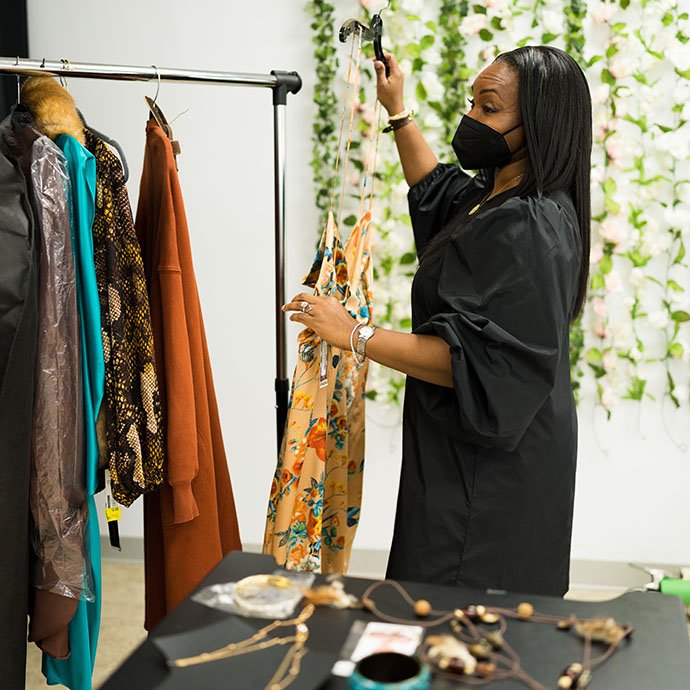 Woman putting clothes on garment rack