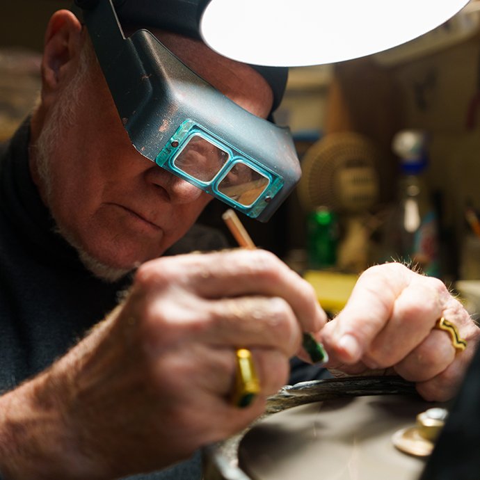 A man wearing special glasses to work on jewelry