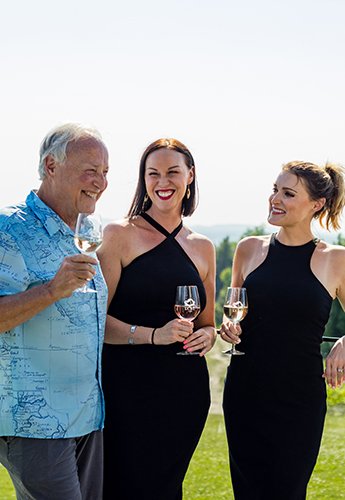 Three people holding wine glasses