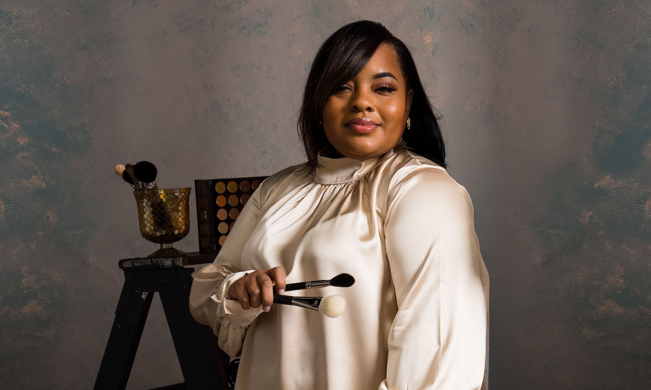 A person holding makeup brushes