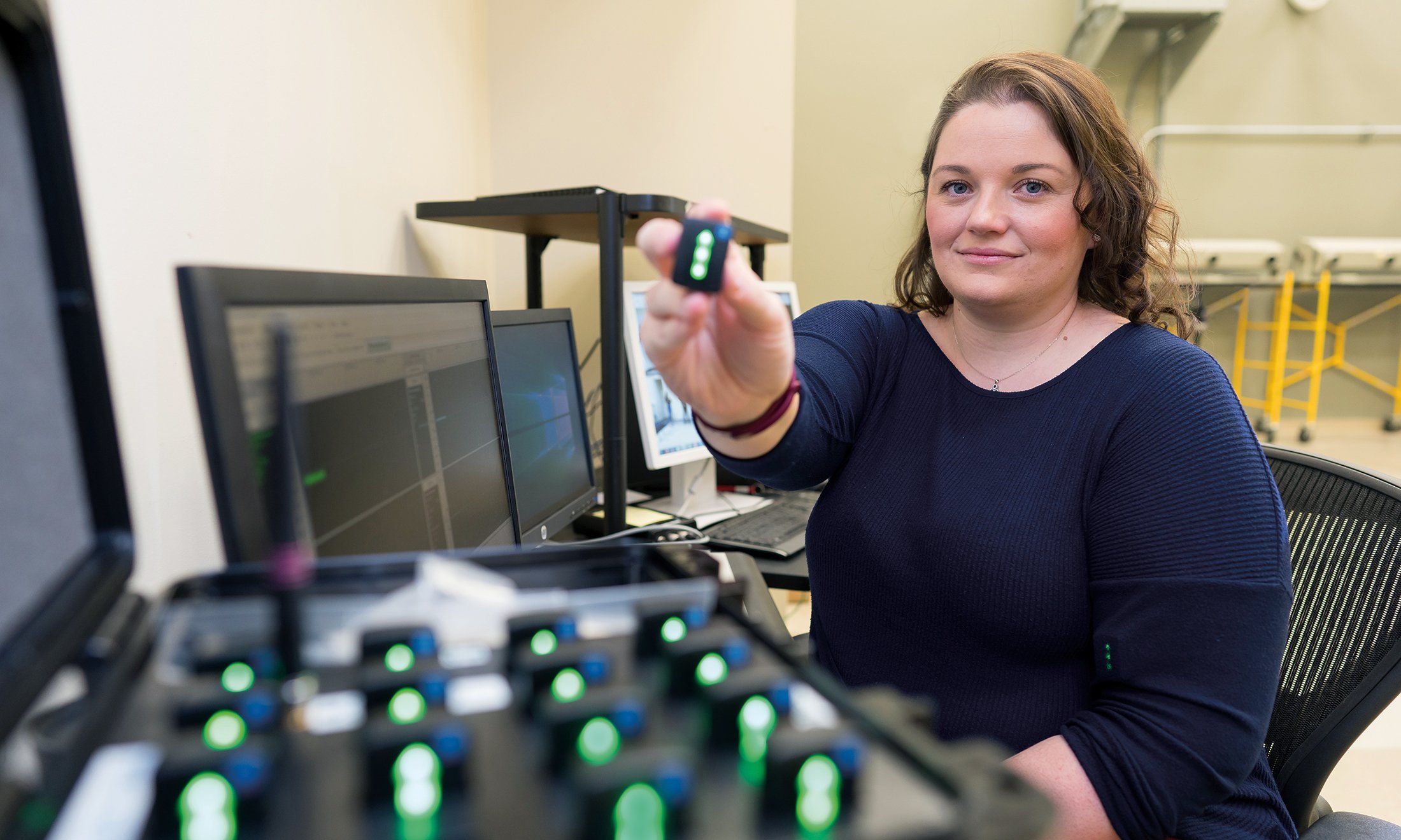 A woman holding up a device.