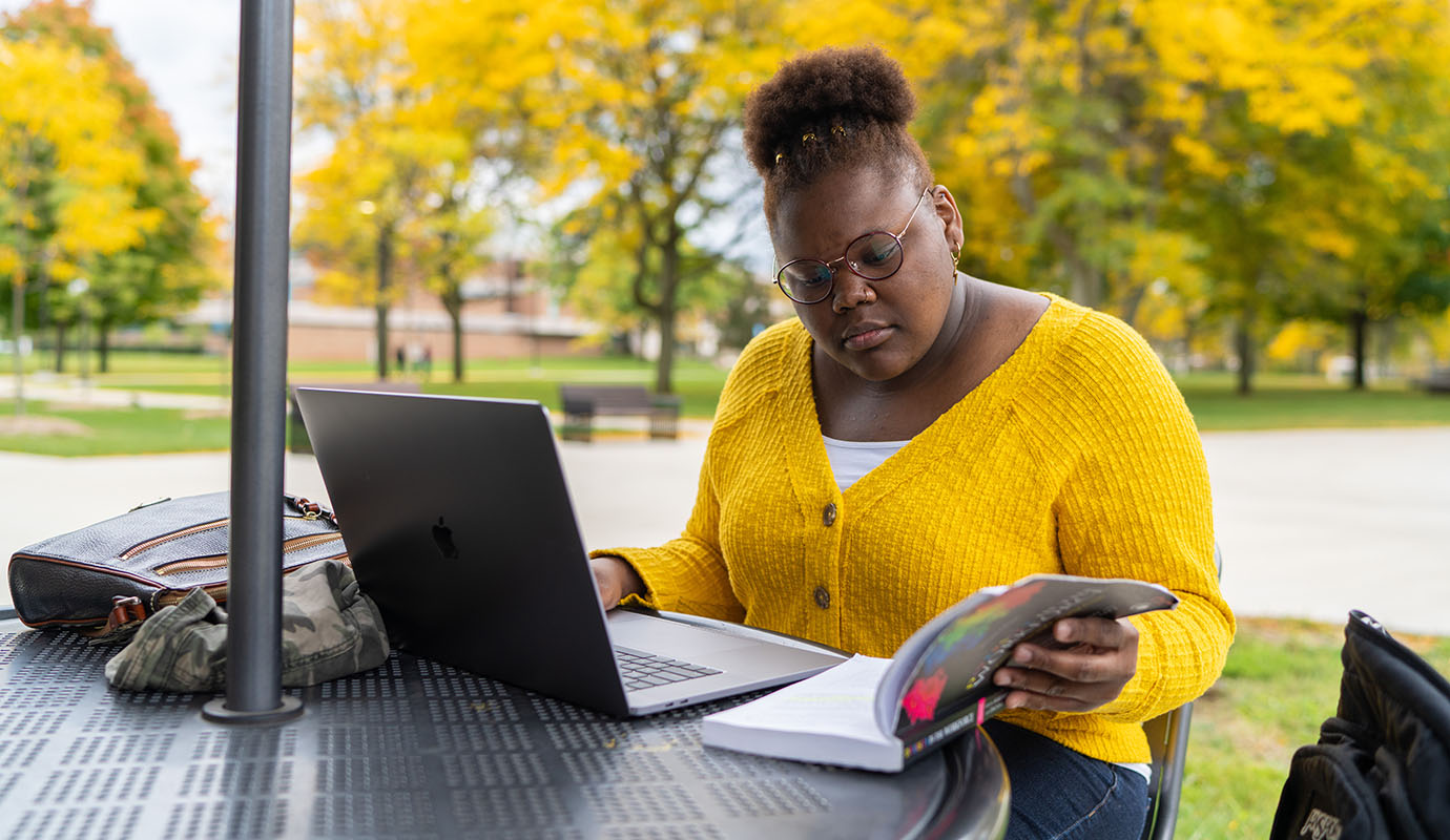 A student studying at a table outside