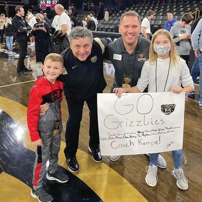 Man with children posing with coach