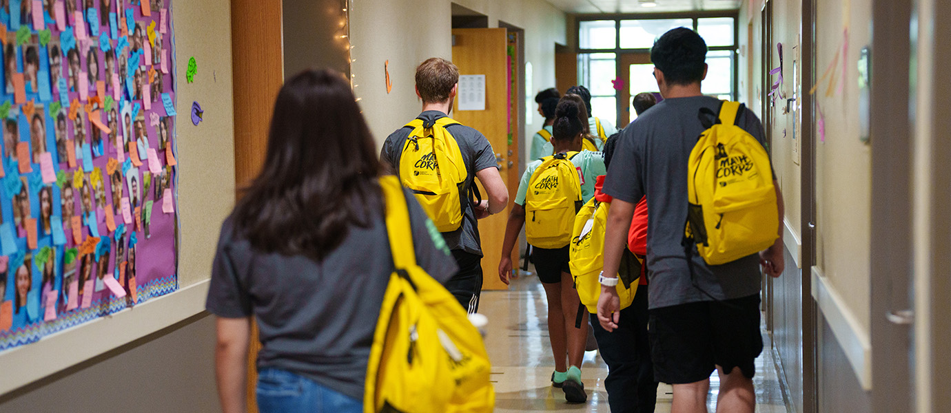Students walking down hall with backpacks