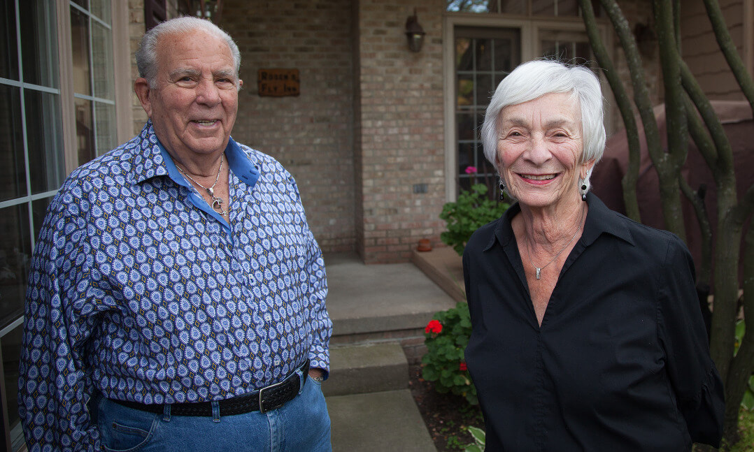 Two people standing outside their home