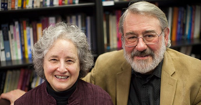 Two people smiling in a library