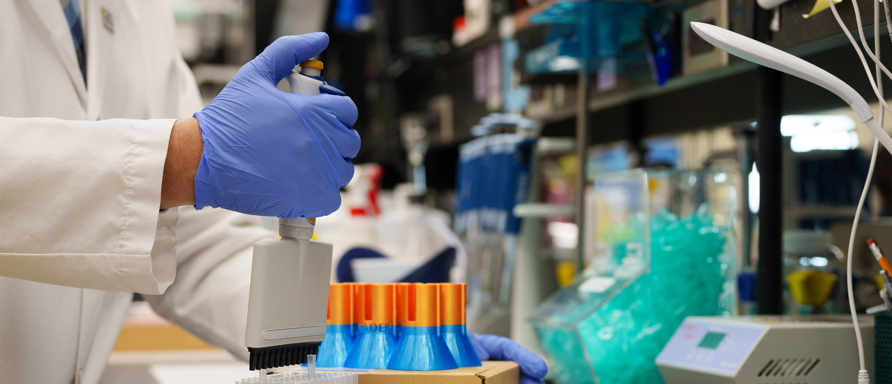 An image of test tubes and a hand in a glove