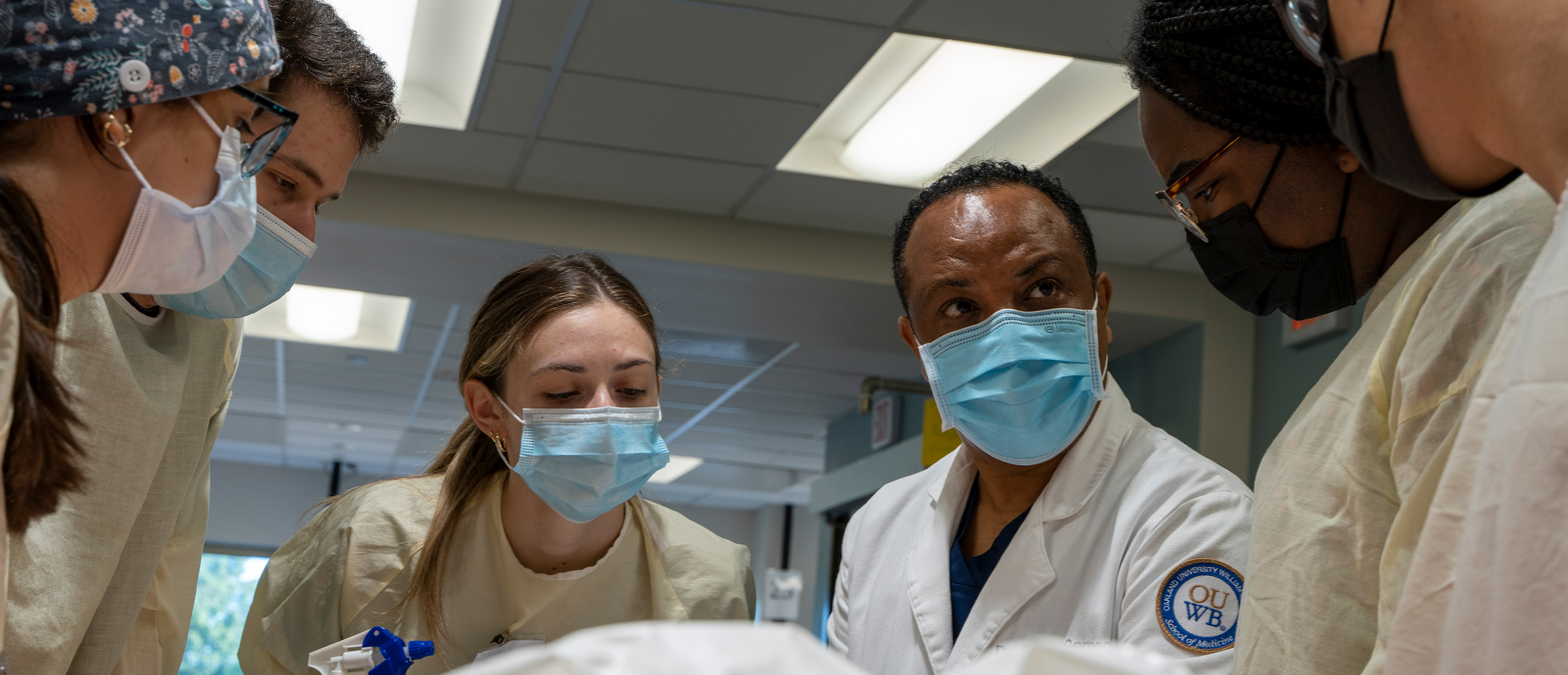 An image of a faculty member and students in the anatomy lab