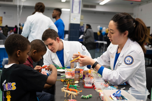 An image of medical students and patients at a health fair