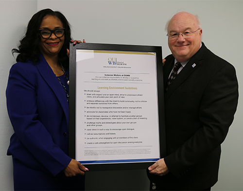 An image of two people holding a sign