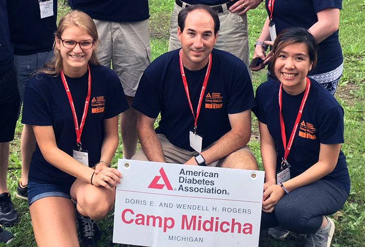 An image of three people holding a sign