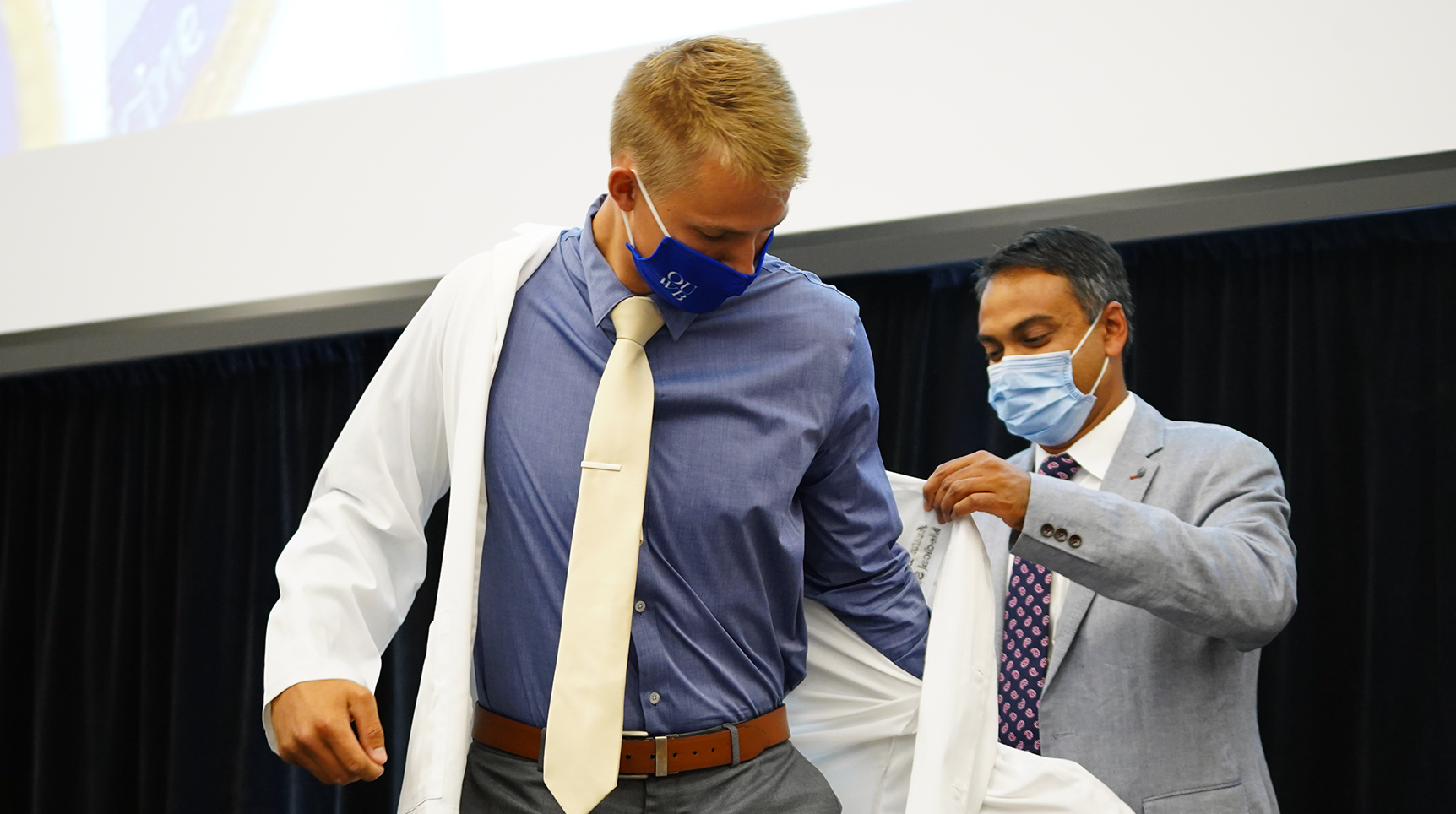 An image of a student getting his white coat