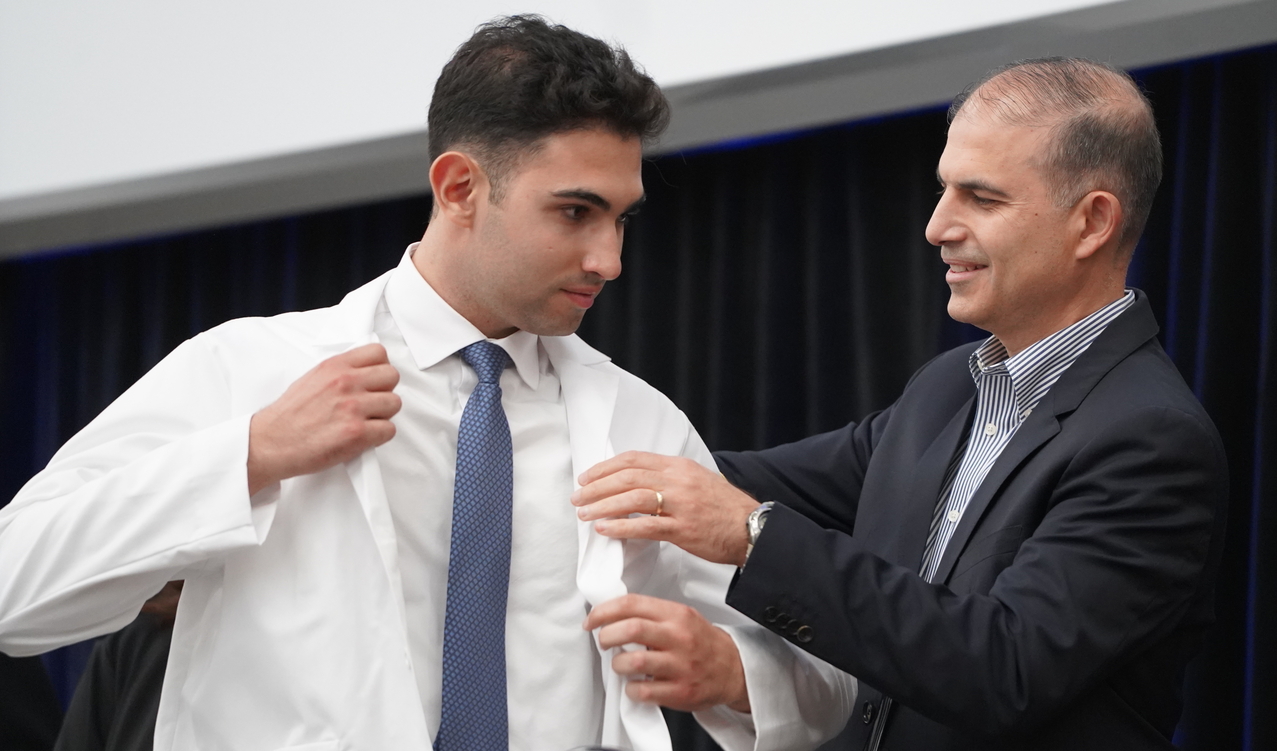 An image of student getting his white coat