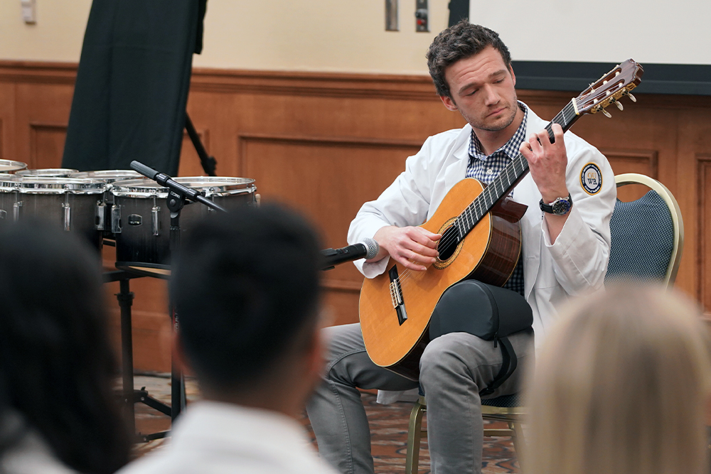 An image of a student playing a guitar