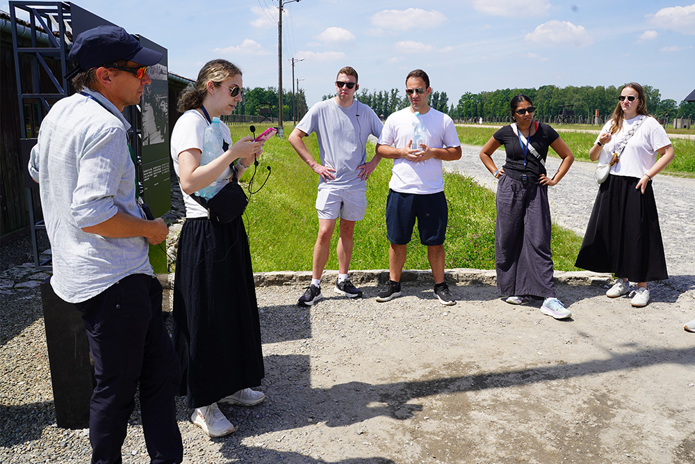 A student reads a testimonial at Auschwitz-Birkenau