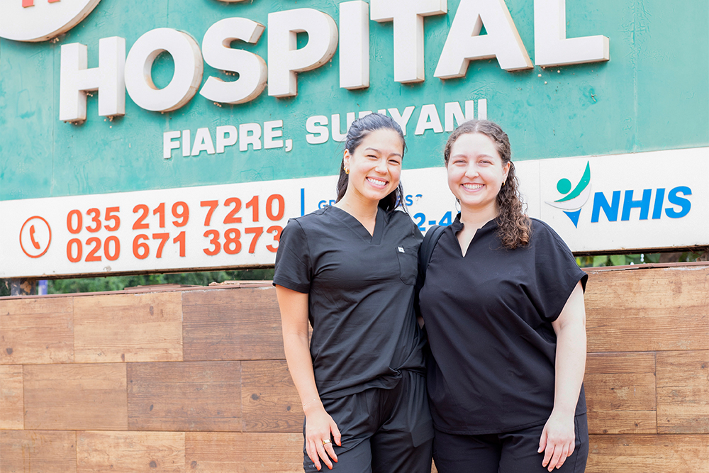 Sophia and Cassandra in front of the SDA Hospital sign