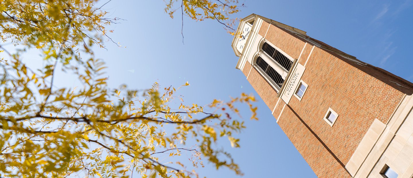 A photo looking up at Elliott Tower through the yellow leaves of a tree.