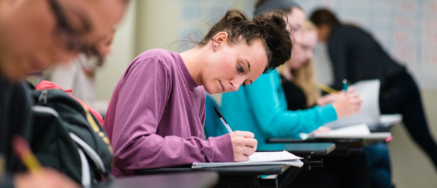 Students at desks taking notes