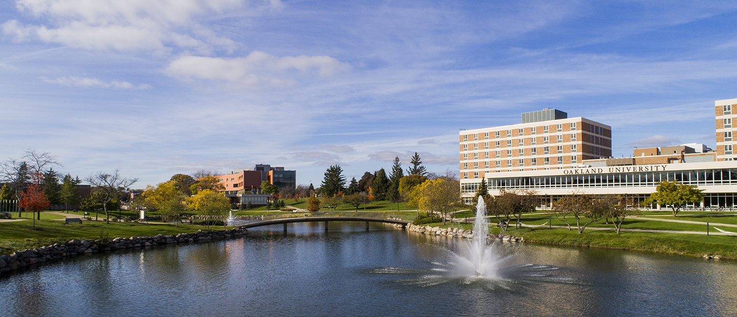 image of Oakland University's campus with a view of Bear Lake, Vandenberg Hall and the Human Health Building