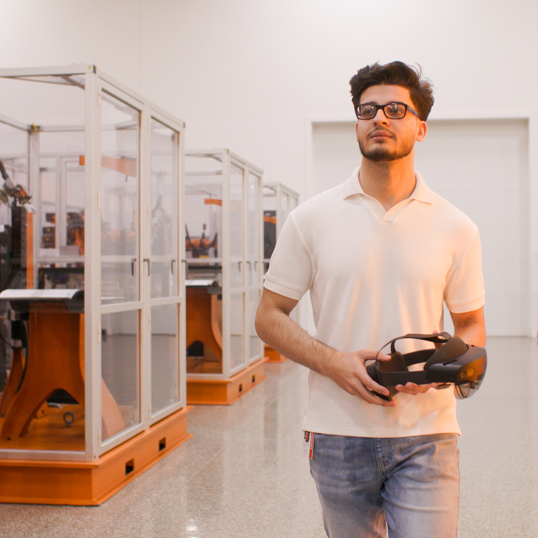 A man walking through a robotics lab