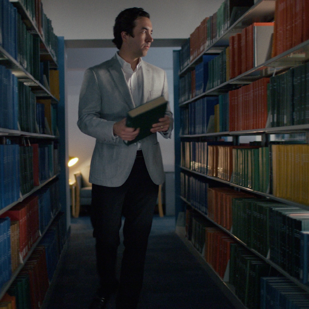 Charlie Rewold walking through a library