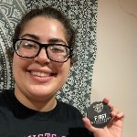 Raneen Allos holding a First Generation Oakland University button.