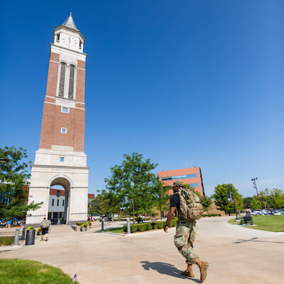 Man in army uniform walks toward Elliott Tower