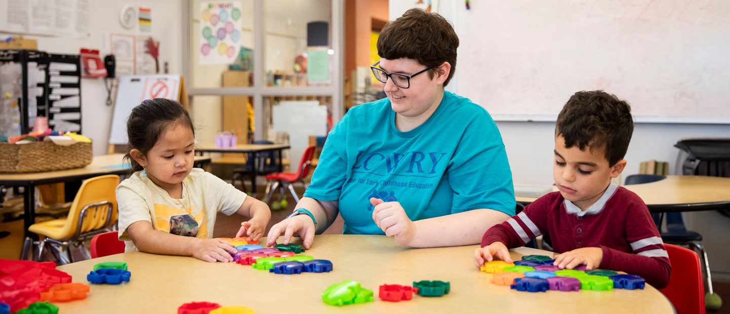_00014_early-childhood-education_bs.jpg Teacher sitting with students at a table