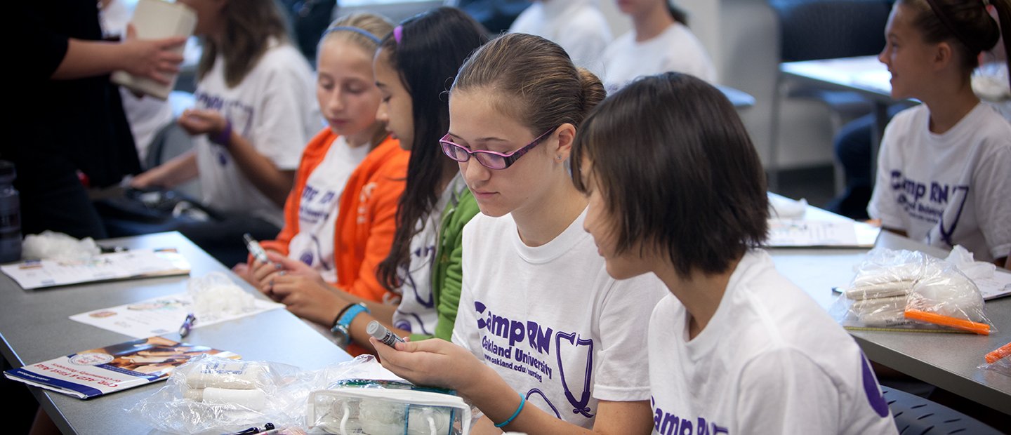 kids wearing Camp R N shirts, seated at long tables in a classroom