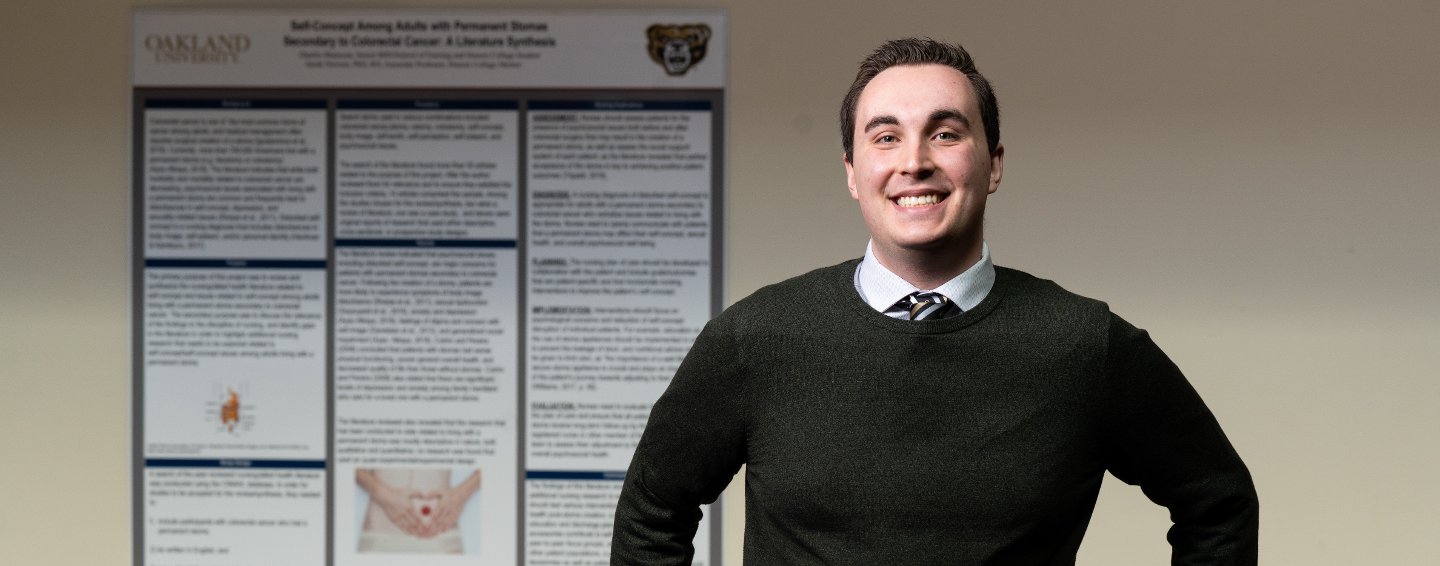 man in front of research poster