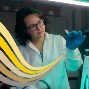 Person holding a small capsule and looking at it